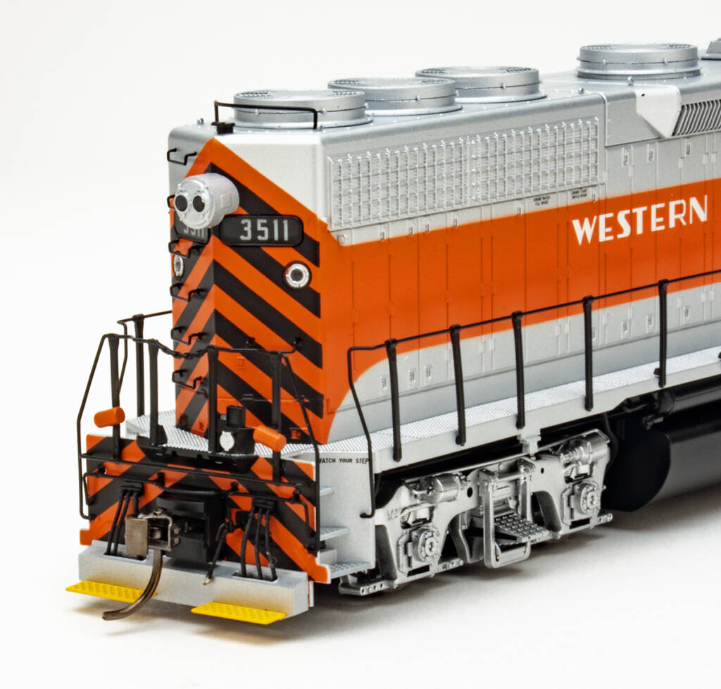 Color photo showing back of HO scale hood unit painted aluminum, orange, and black with yellow footboards on white background.
