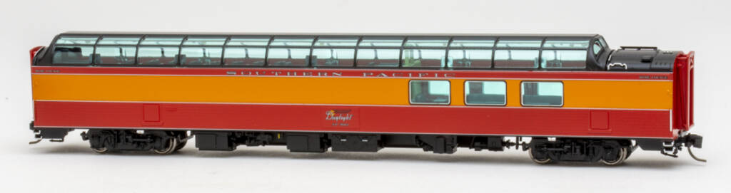 Color photo of N scale fluted-side Southern Pacific 3/4 dome lounge painted red, orange, and black on white background.