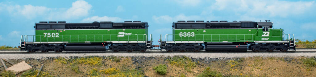 Color photo showing HO EMD SD40-2 and SD40-2B in green, black, and white paint on scenicked base with a sky blue backdrop.