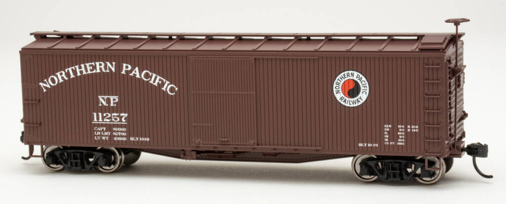 Color photo of brown HO scale boxcar with red, white, and black graphics on white background