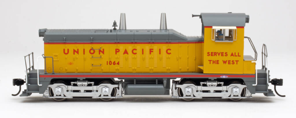 Color photo showing side view of HO scale switcher painted yellow and gray with red graphics on white background.
