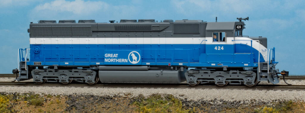 Color photo of HO scale EMD hood unit painted gray, white, and blue on scenicked base with a sky blue backdrop