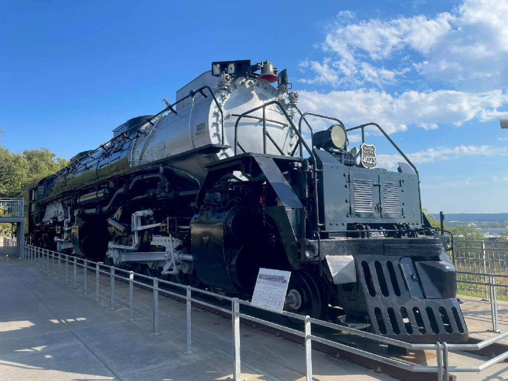 Large black and grey steam locomotive in a park.