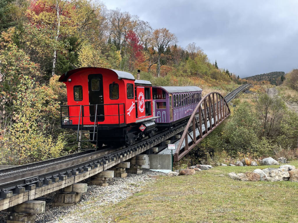 red diesel-powered cog railway train heading up mountain.