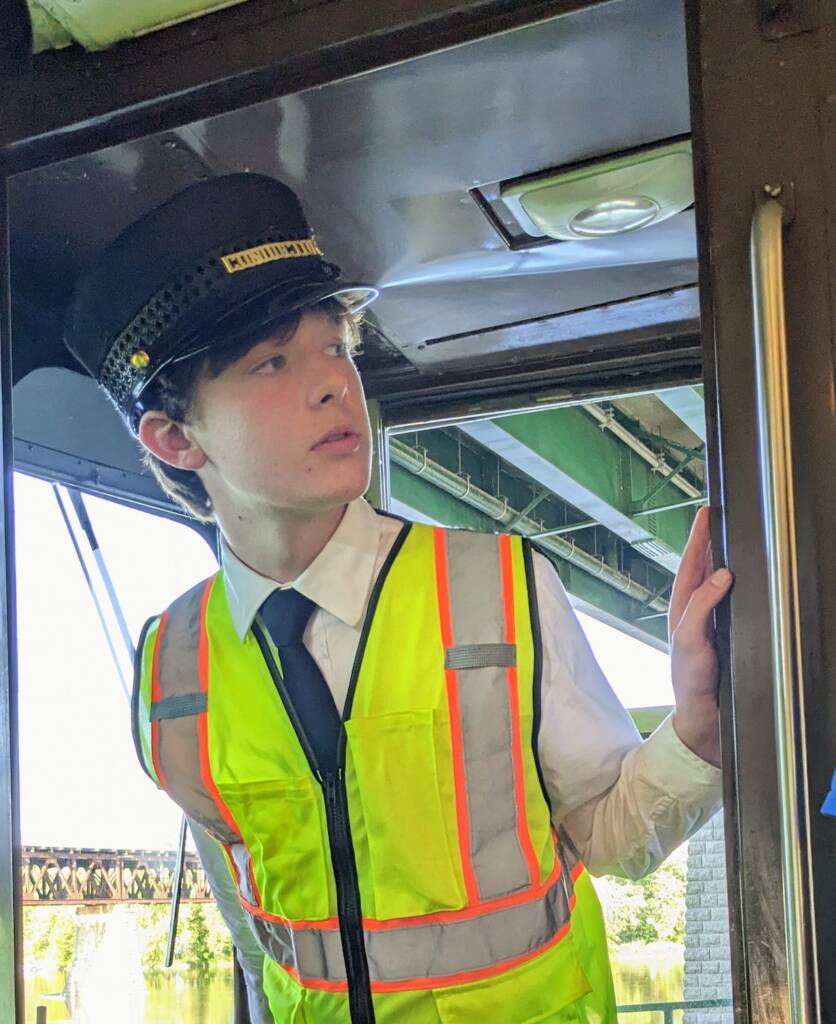 Young individual looking out from the control stand of a trolley
