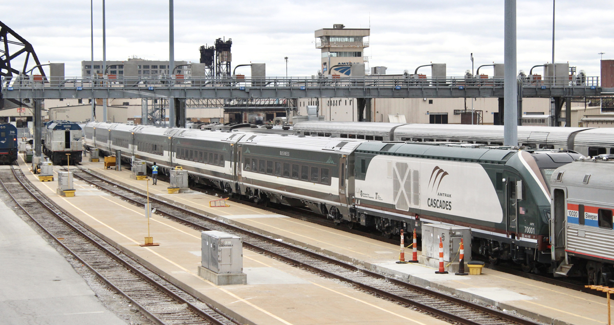 New green, white, and brown passenger train in Amtrak Chicago coach yard