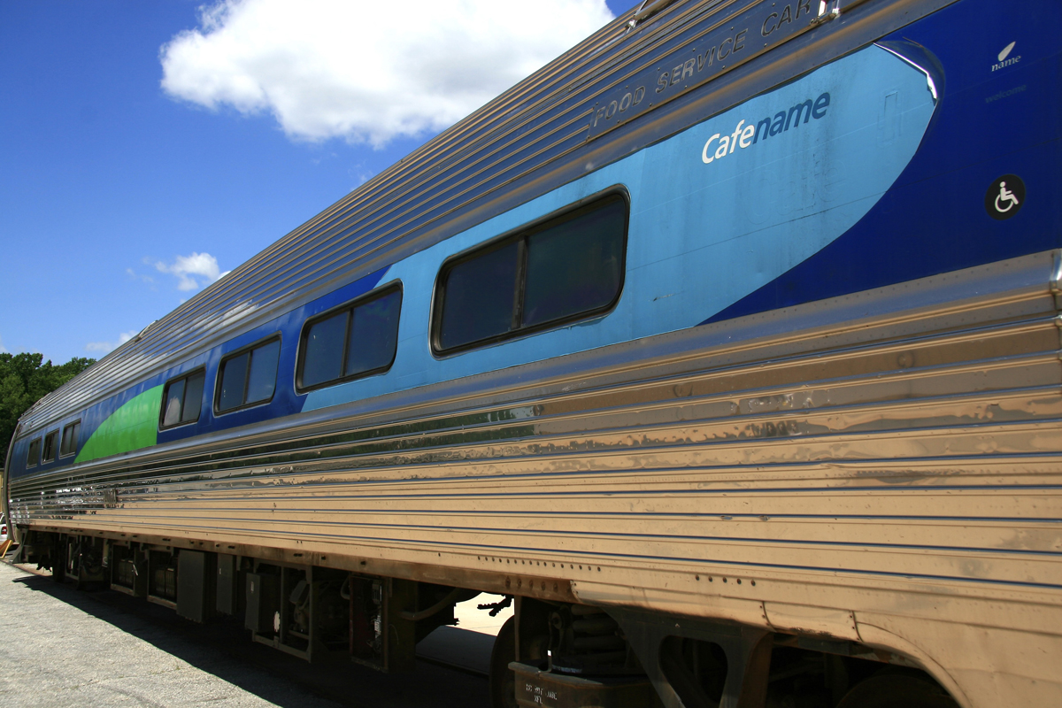 Amfleet car with light blue, dark blue, and green design on window stripe