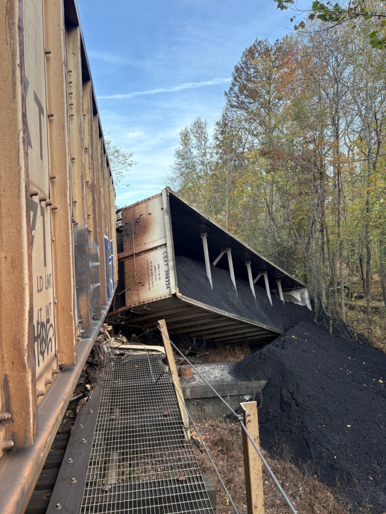 Overturned coal hopper next to bridge