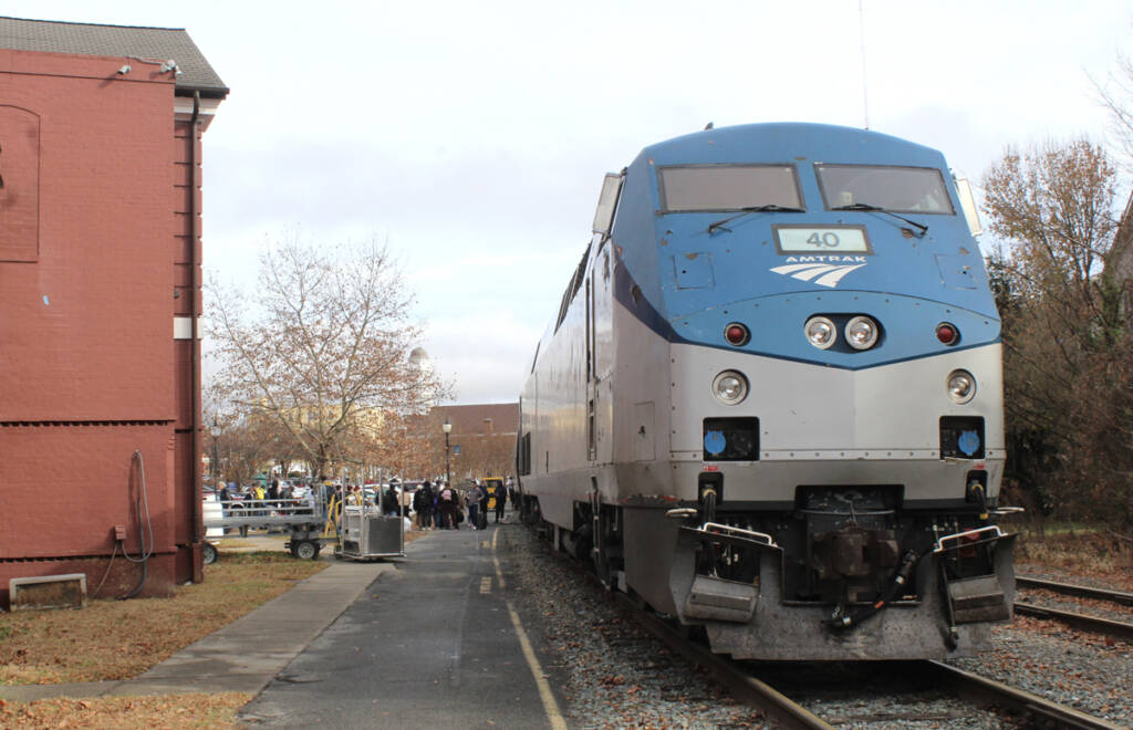 Passenger train at station with large number of people boarding