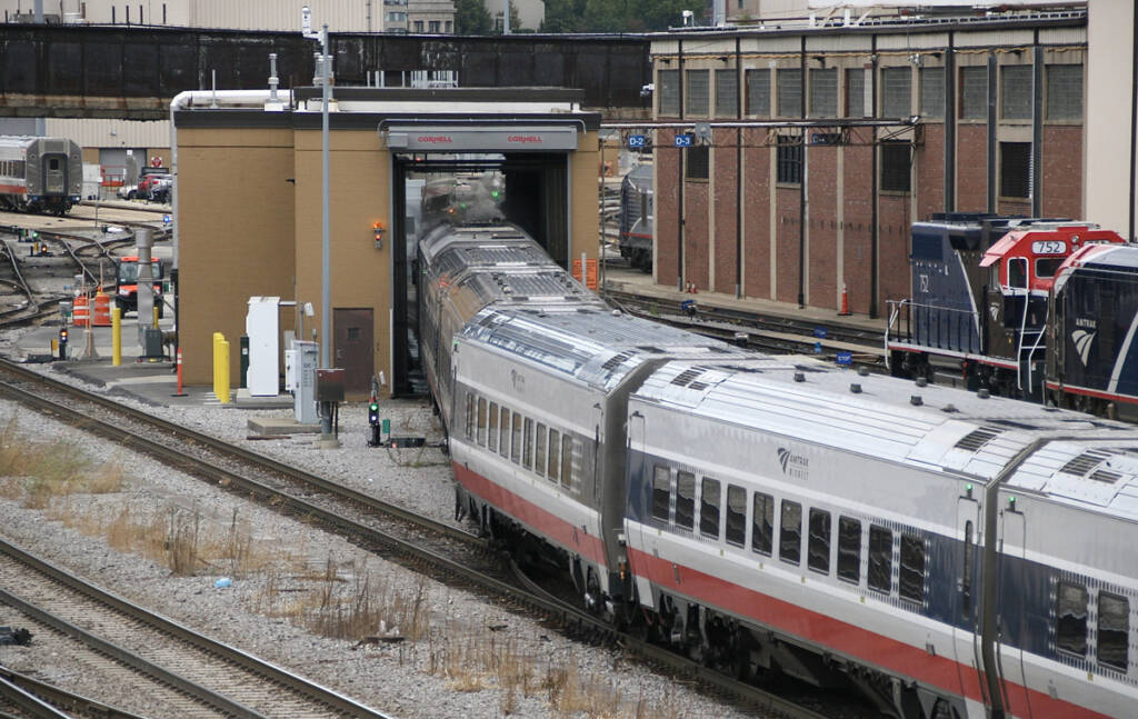 Train moving through small building across tracks