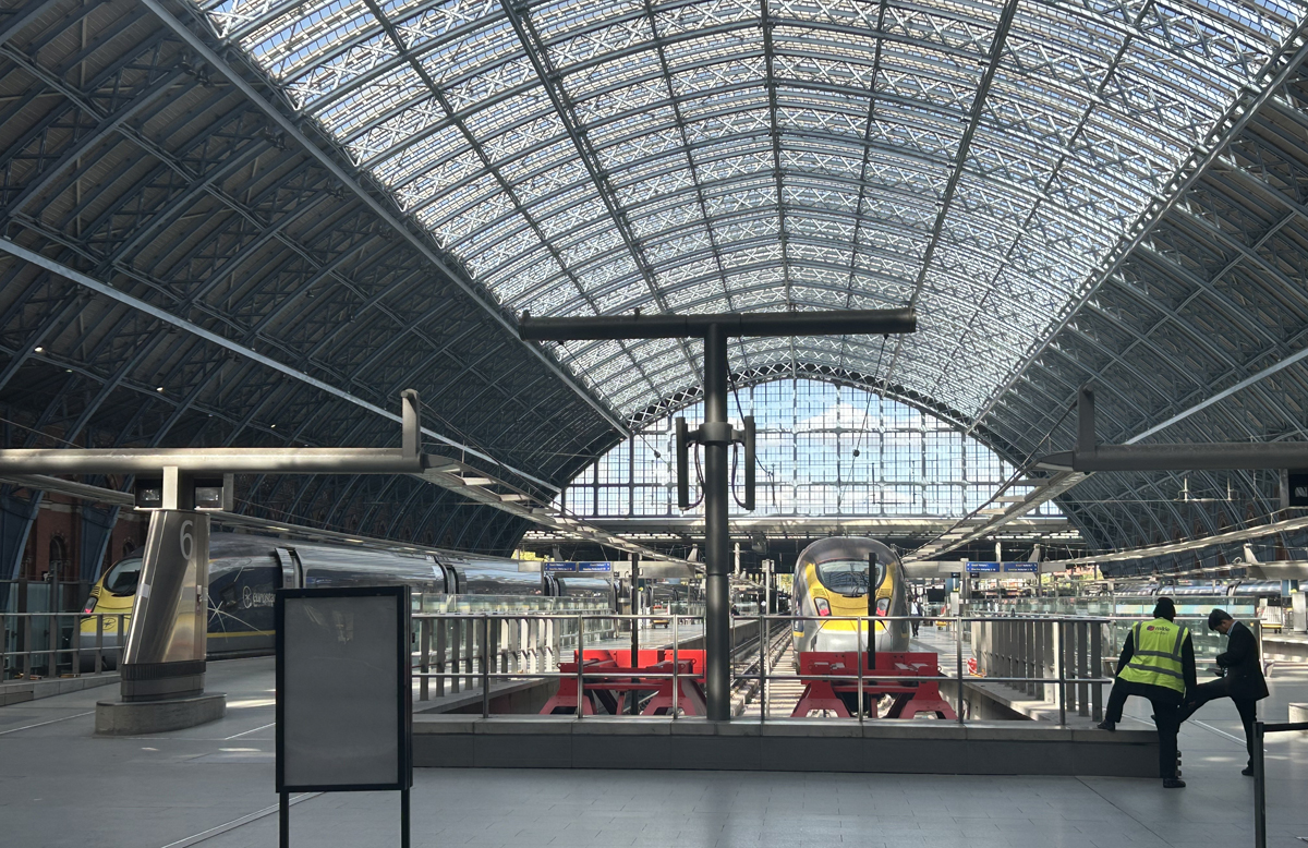 Trains in station with large arch roof over platforms