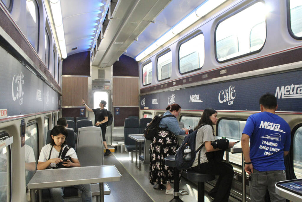 Interior of bilevel commuter car with upper-level seats removed and tables added for cafe service