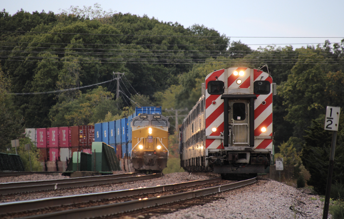 Commuter train led by cab car passes intermodal train