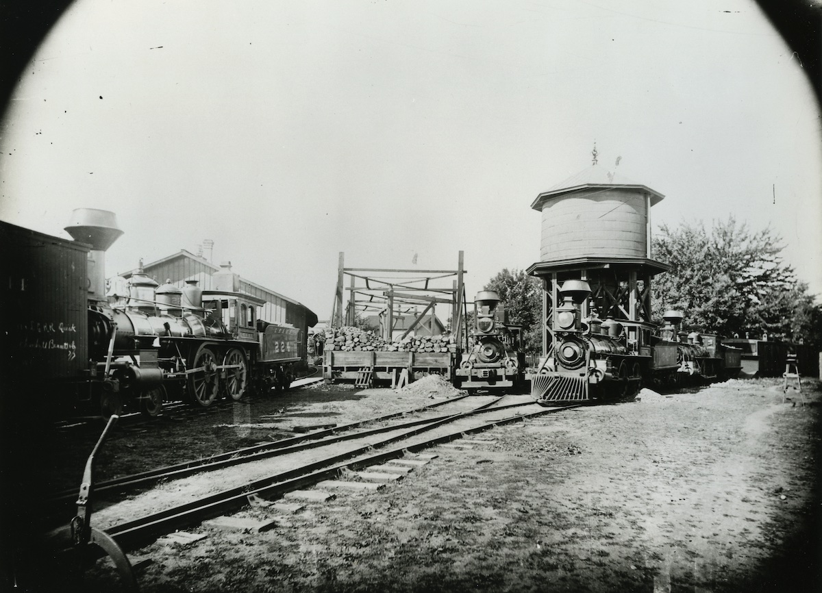 Late 19th-century type steam locomotives at an engine facility.