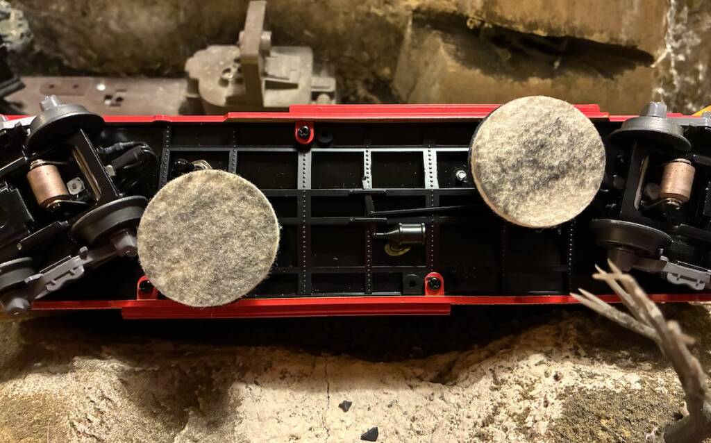 underside of model boxcar with two dirty cleaning pads