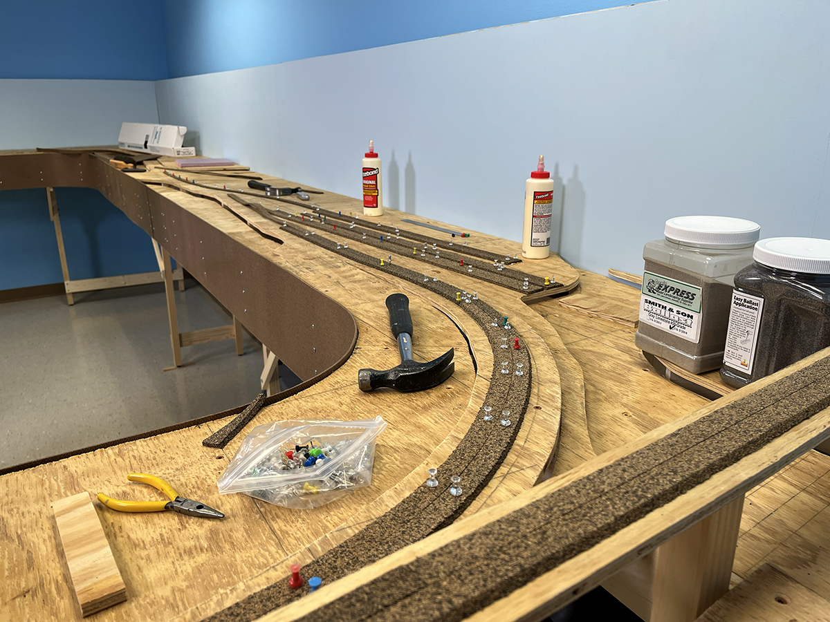 A partly built model railroad layout, with cork roadbed being laid out in preparation of track laying