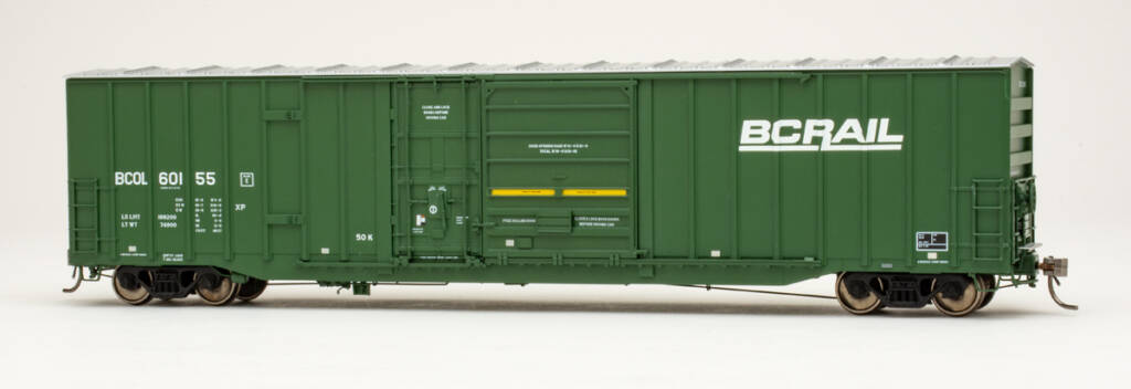 Color photo of HO scale boxcar with exterior posts and plug and sliding doors painted dark green with yellow and white graphics on white background. 
