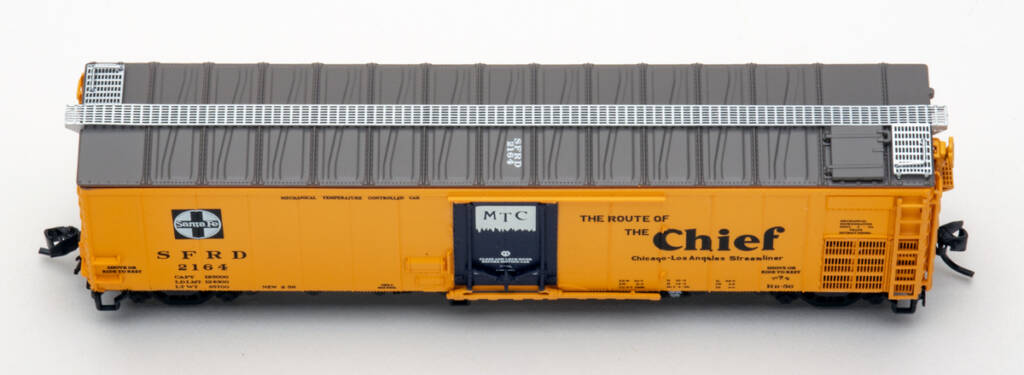 Color overhead photo of N scale steel refrigerator car painted yellow with brown roof, blue door, and silver see-through running board on white background.