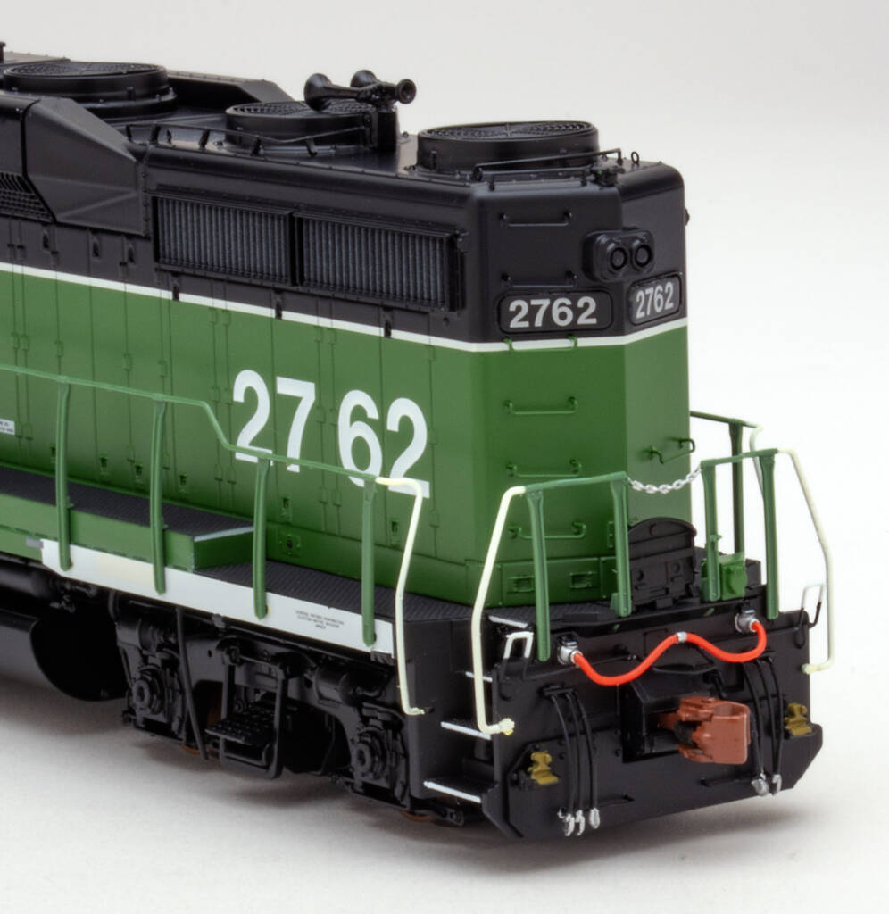 Color photo showing rear of long hood on HO diesel painted green, black, and white on white background. 