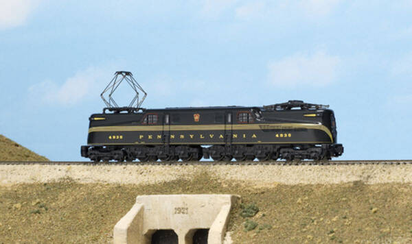 A black model streamlined locomotive with a gold stripe and gold lettering