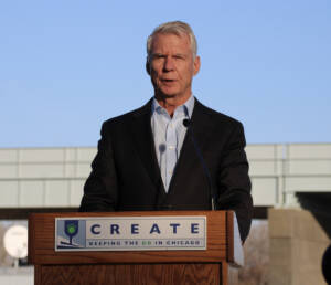 Man speaking at podium with CREATE sign
