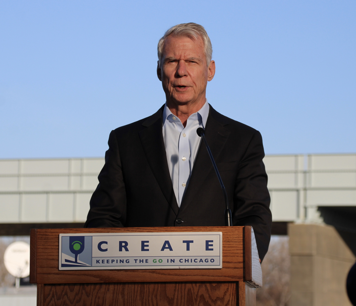 Man speaking at podium with CREATE sign