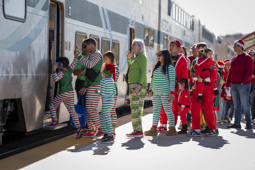 People in pajamas or holiday clothing waiting to board train