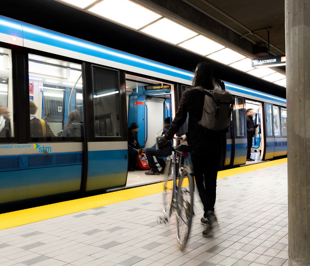 Man with bicycle on station platform with rapid transit train