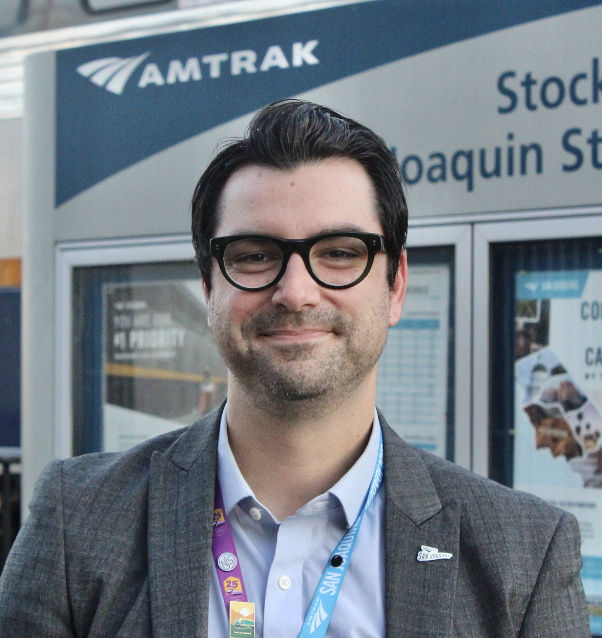 Man standing in front of Amtrak sign