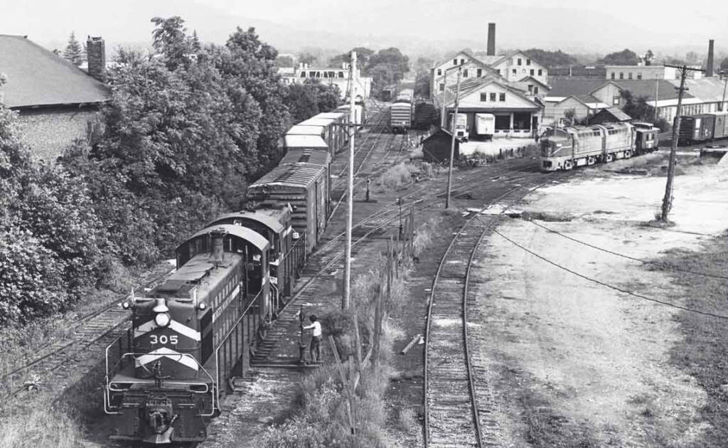 A vintage black and white photograph of a diesel locomotive in a switching yard