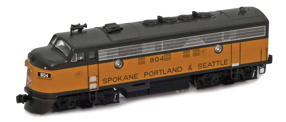 Color photo of Z scale cab unit painted yellow and black with red, white, and black graphics on white background