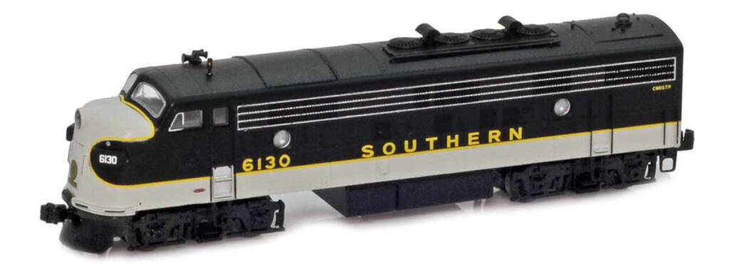 Color photo of Z scale EMD cab unit painted black, white, and gold with gold and white graphics on white background.