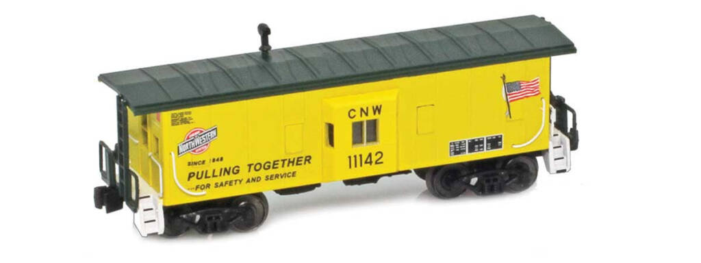 Color photo of Z scale bay-window caboose painted yellow and green with red, white, and black graphics and American flag.