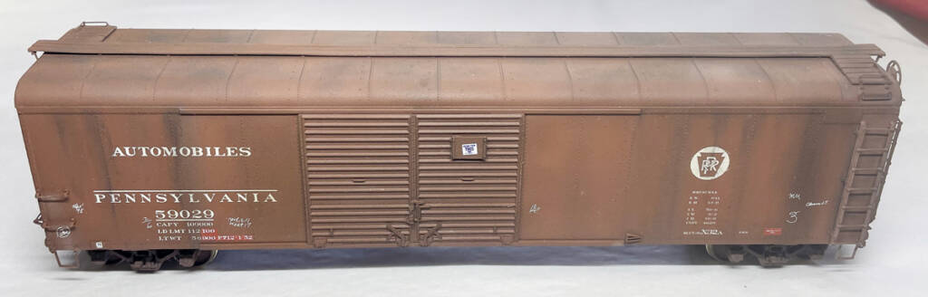 Color illustration of N scale Difco dump car painted mineral red with white graphics on white background. 