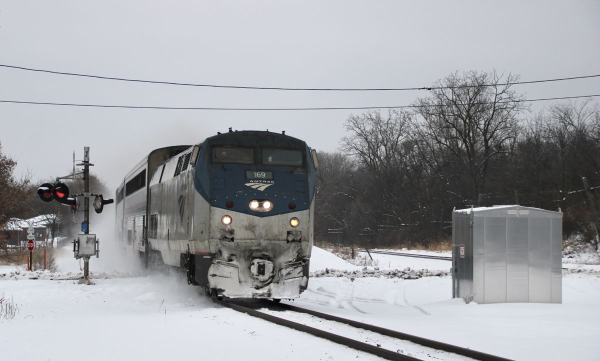Passenger train at grade crossing in snow