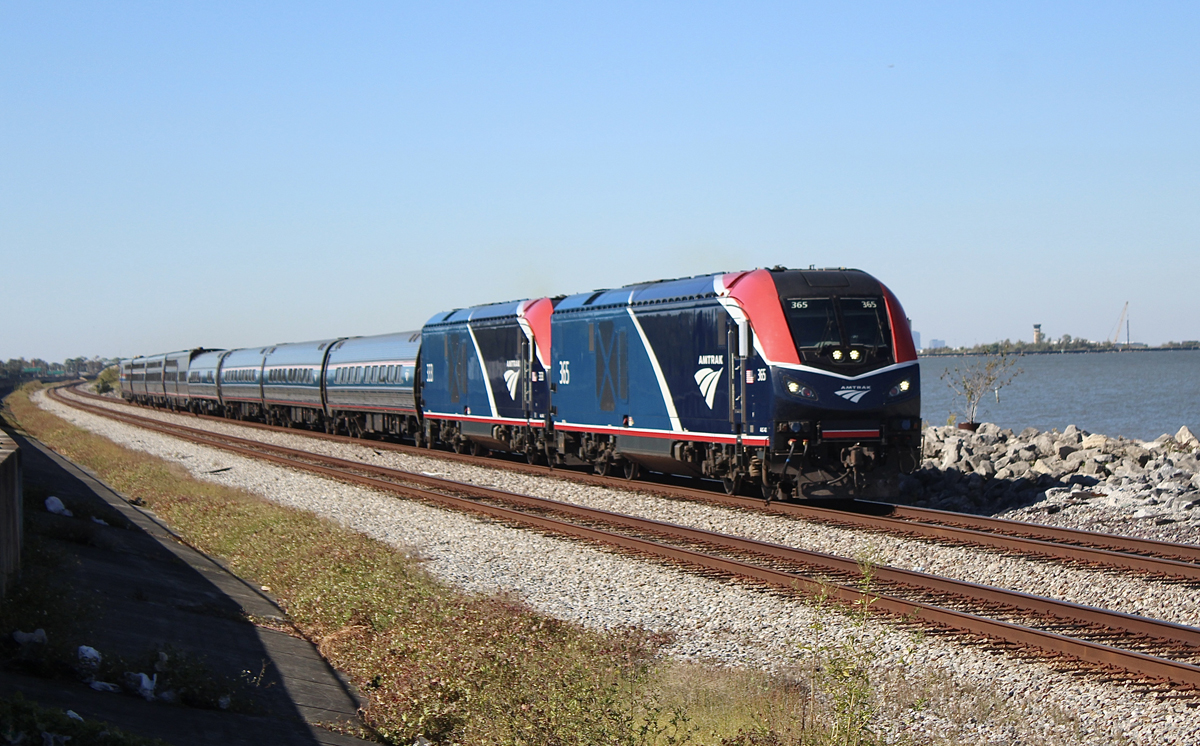 Passenger train on double-track line next to body of water