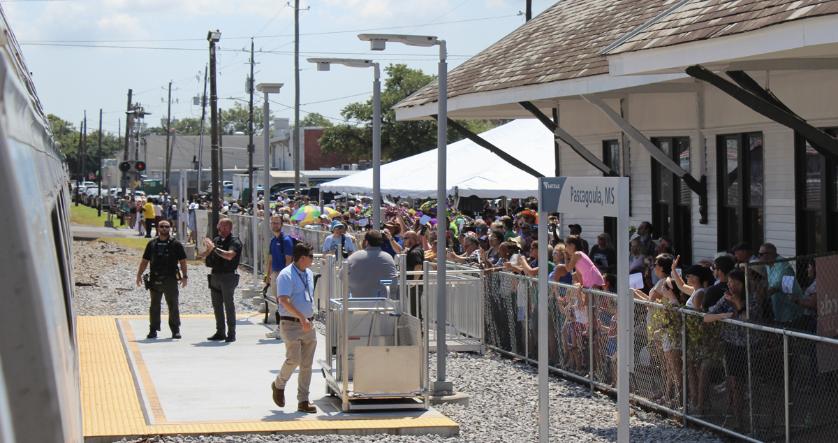 Crowd behind fence at train station