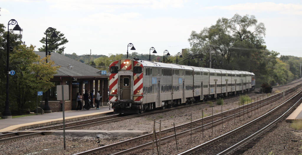Bilevel commuter train led by cab car at station