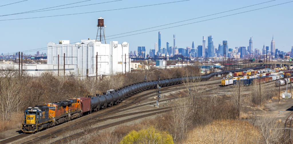 Union oil train at railroad yard with city skyline in background