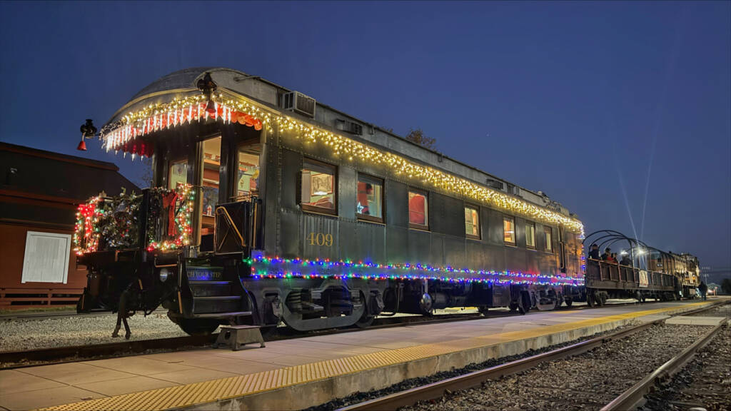 Open-platform private car with Christmas Lights at back of train