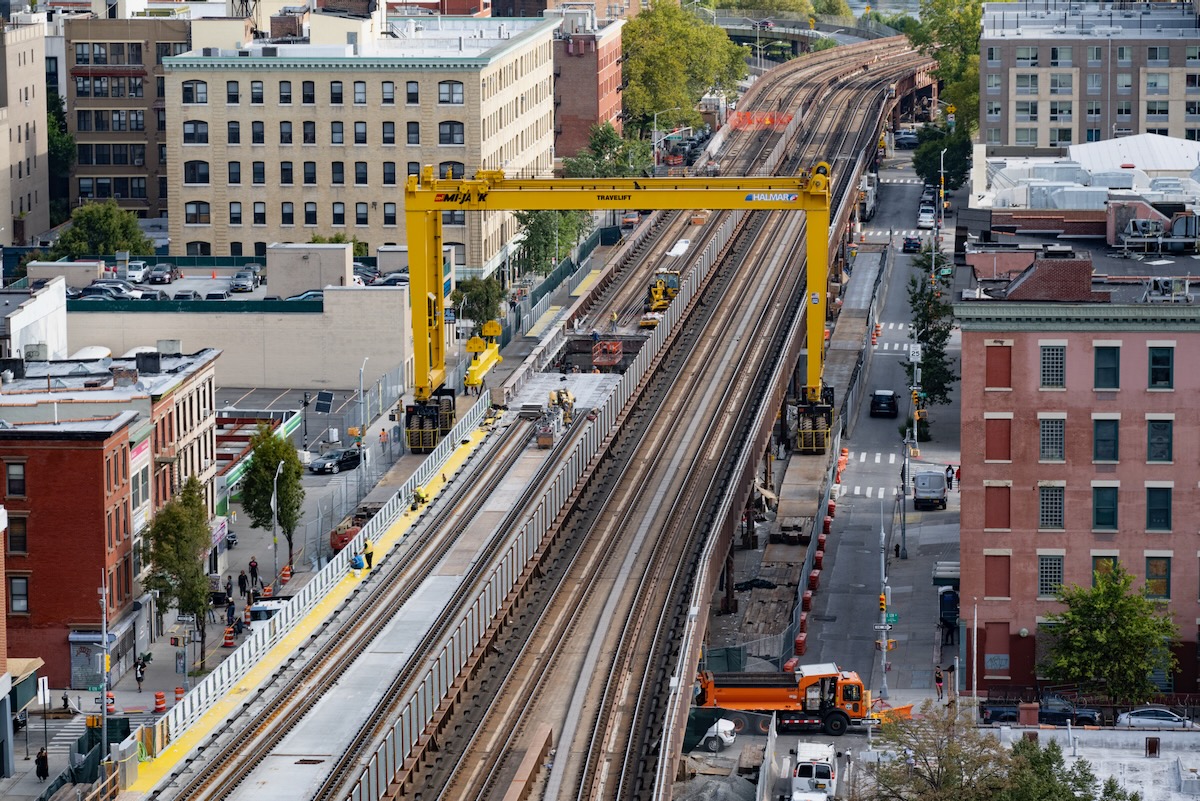 Aerial view of bridge project with tracks straddled by yellow gantry crane
