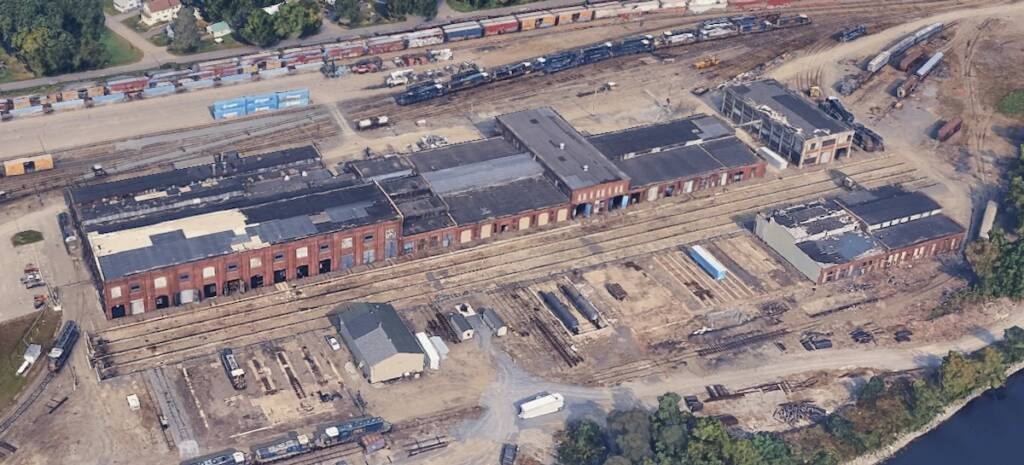 Aerial view of large brick rail shop building
