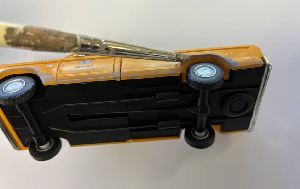 underside of model truck with paint brush