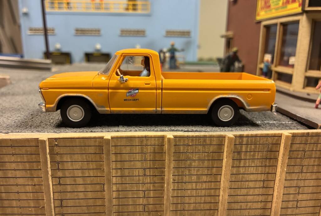 yellow model truck with figure inside
