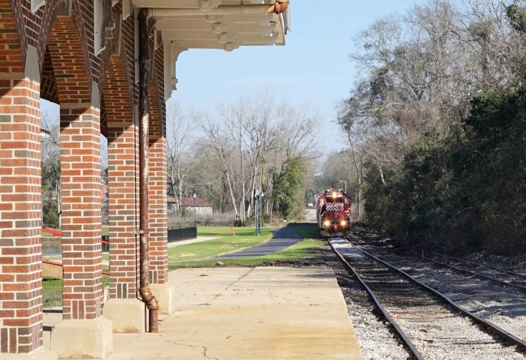 Train with red locomotive approaching in distance