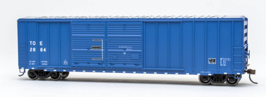 Color photo of HO scale double-door boxcar with exterior posts painted dark blue with black and white graphics on white background.