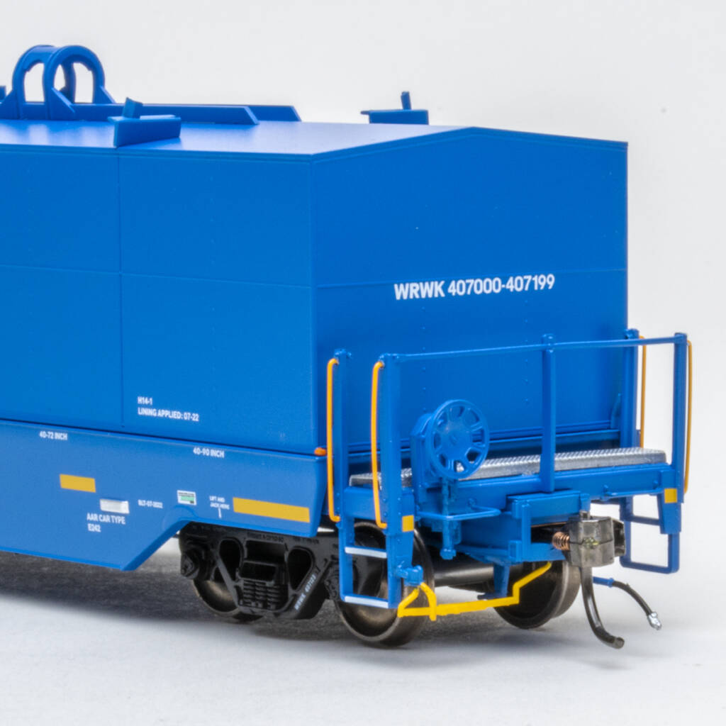 Color photo showing B end of modern HO scale coil car painted blue with white and yellow graphics and black trucks with metal wheelsets.