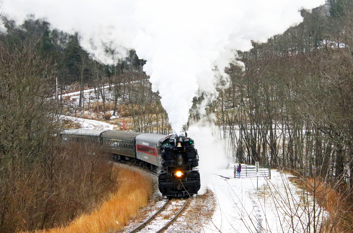 Large black steam locomotive with passenger train in the snow. No. 1309 makes first 2026 trip.