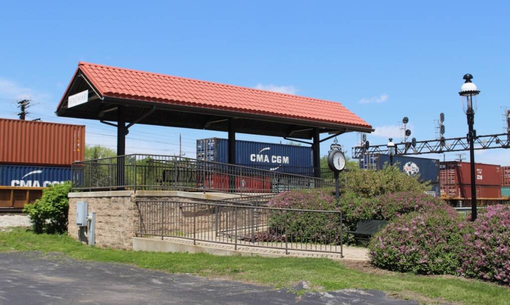 Covered, elevated platform next to railroad tracks.
