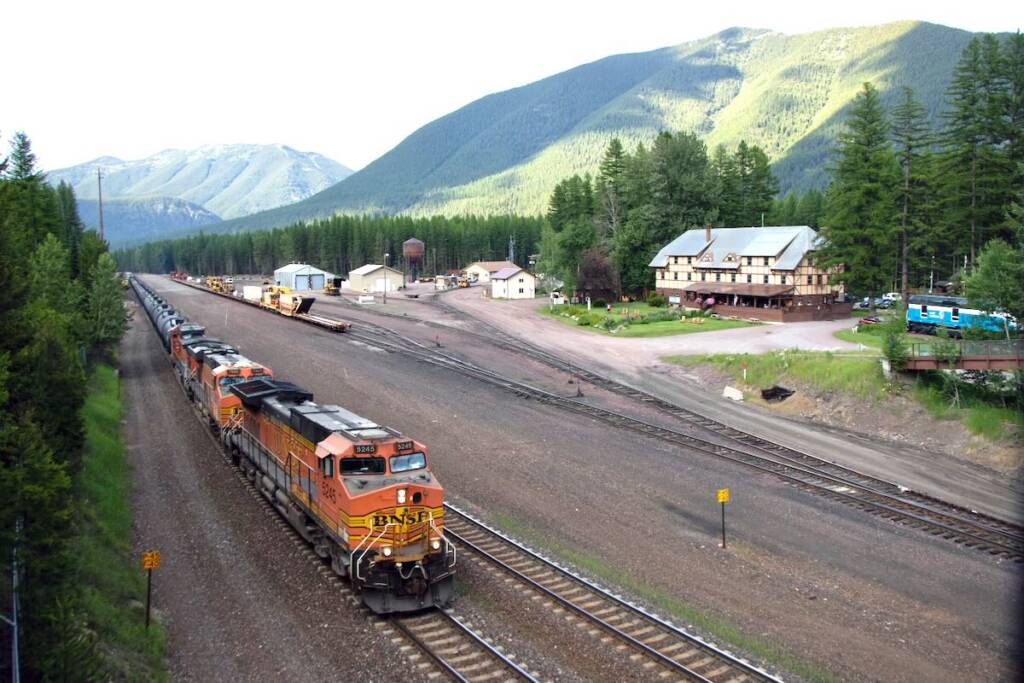 Freight train passing small lodge in mountains